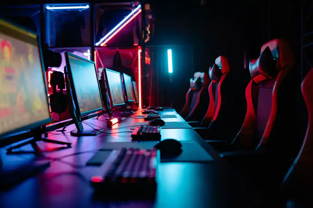 Comfortable gaming lounge area with large screen TVs and next-gen consoles